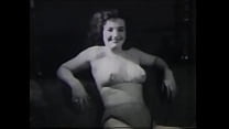 A mature lady with dark silky hair takes part in the filming of a 60s porn film