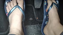 Sweaty feet in really tasty flip flops pedal pumping on the pedals of the car